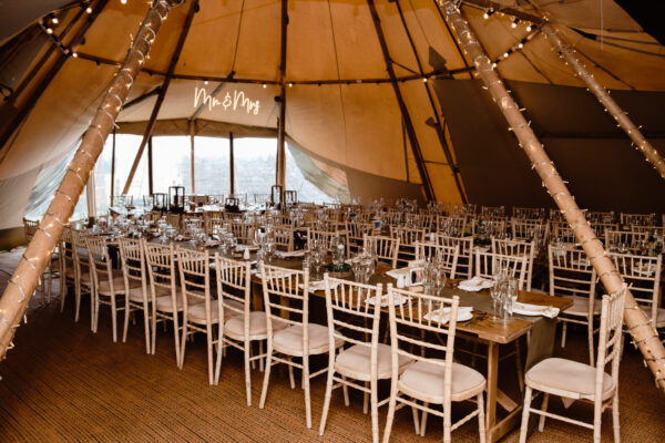 tipi wedding - banqueting style tables with limewash chairs