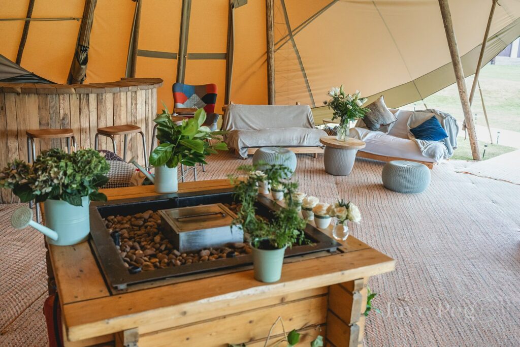 Tipi decoration ideas, DIY tipi interior, fire pit inside tipi decorated with rose buds and green wedding floral decorations